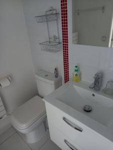 a white bathroom with a toilet and a sink at Chambre d'hôtes du Carrousel in La Teste-de-Buch