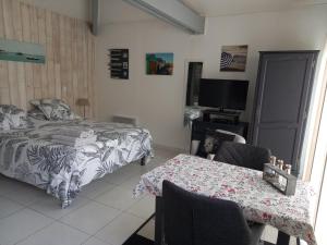 a bedroom with a bed and a table and a television at Chambre d'hôtes du Carrousel in La Teste-de-Buch