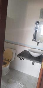 a bathroom with a toilet and a sink at Casa Com 2 Quartos Barra Serinhaem - BA in Ituberá