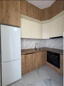 a kitchen with a white refrigerator and a sink at D&M Lux2 in Podgorica