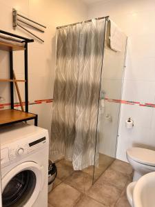 a bathroom with a washing machine and a toilet at Apartaments IRI in Pineda de Mar