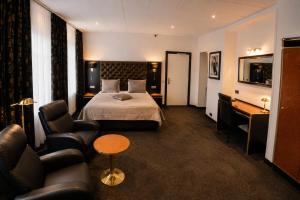 a hotel room with a bed and a couch at Hotel Le Beau Rivage in Middelburg