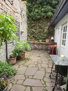 a stone patio with a table and plants next to a building at Pension Reuss - Hotel garni in Erfurt