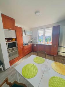 a kitchen with a white table and some chairs at Apartamenty na Pięknej 24-2 in Nowy Sącz