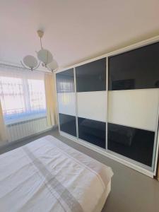 a bedroom with a large bed and a large window at Apartamenty na Pięknej 24-2 in Nowy Sącz
