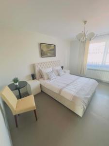 a bedroom with a bed and a table and a chair at Apartamenty na Pięknej 24-2 in Nowy Sącz