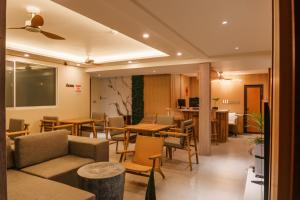 a restaurant with tables and chairs and a couch at Island Ufaa Dharavandhoo in Dharavandhoo