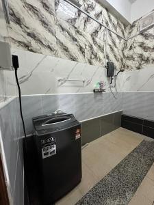 a trash can in a bathroom with a marble wall at RY Homestay in Tawau +13 photos