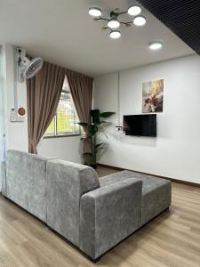 a living room with a couch and a tv at RY Homestay in Tawau