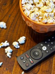 a remote control sitting next to a bowl of popcorn at Entre Muralhas - Cozy Apartment Elvas I in Elvas +32 photos