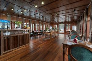 a large room with wooden floors and tables and chairs at Petit Prince Cruise in Cat Ba