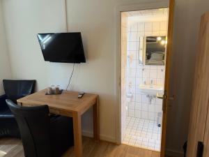 a room with a table and a bathroom with a shower at Haus Waldesruh in Nettetal +28 photos