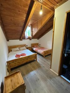 a bedroom with two beds in a room with wooden ceilings at Natyra balcony in Valbonë +17 photos