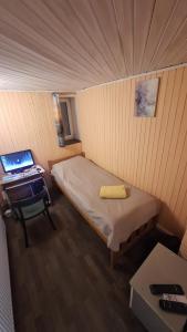 a small room with a bed and a desk with a laptop at Guest House Krista in Jūrmala +31 photos