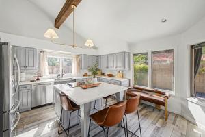 a kitchen with white cabinets and a table and chairs at NEW Royal Palms Retreat with Pool Spa & Pool Table in Tempe
