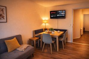 a room with a table and chairs and a couch at Modernes City-Apartement - 6 Gäste in Weingarten