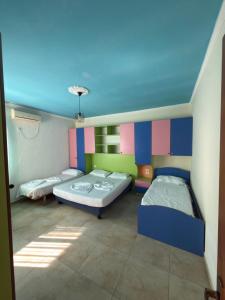 a room with two beds and a blue ceiling at Alfas Beach Apartments in Shëngjin