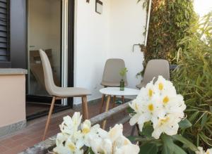 two chairs and a table on a patio with white flowers at Modernes City-Apartement - 6 Gäste in Weingarten