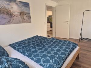 a bedroom with a bed with a blue comforter at Modernes City-Apartement - 6 Gäste in Weingarten