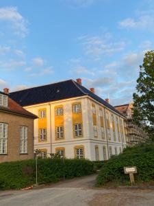 a large white building with a black roof at Cozy Corner ferielejlighed in Augustenborg