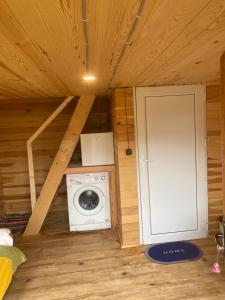 a small room with a washing machine and a door at Towers Inn Cottage in Mestia