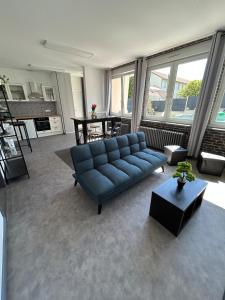 a living room with a blue couch and a table at La Parenthèse Gîte in Créhange