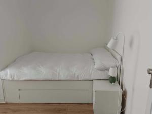 a white bed in a white room with a lamp at Cichy Kącik in Wadowice
