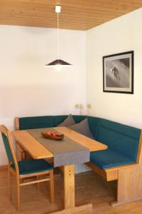 a dining room with a table and a blue couch at Haus Schröcker in Gaschurn