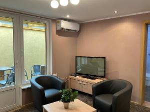 a living room with two chairs and a television at Jaani 2-1 Apartment in Pärnu