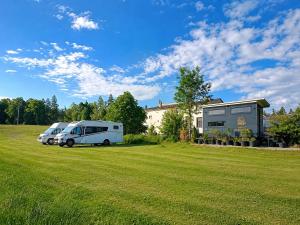 two rvs parked in a field in front of a house at Boží maringotka in Humpolec