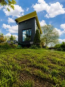 a small house sitting on top of a grass field at Boží maringotka in Humpolec +6 photos