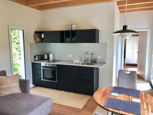 a kitchen with black cabinets and a table in a room at Haus zum See in Uhldingen-Mühlhofen