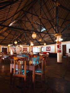 a dining room with tables and chairs and a large ceiling at The Last Village Lodge in Athi River