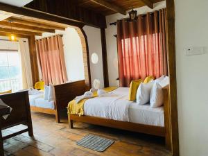 a bedroom with two beds in a room with a window at Infinity Winter Resort in Nuwara Eliya +25 photos