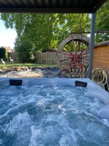 a hot tub with a wheel in a backyard at Le Moulin d'Oscar & Spa - Mulhouse Nord in Baldersheim +130 photos