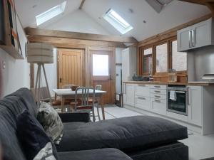 a living room with a couch and a kitchen with a table at Oak framed appartment in Chester