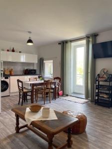 a kitchen and living room with a table and chairs at Gite de la vallée in Rochechouart