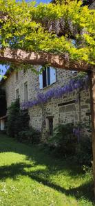 a building with purple flowers on the side of it at Gite de la vallée in Rochechouart