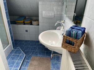 a bathroom with a sink and a mirror and blue tiles at Panoramic Alpine Residence in Eisenerz +23 photos