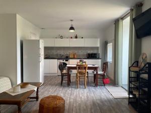 a kitchen and dining room with a table and chairs at Gite de la vallée in Rochechouart +11 photos