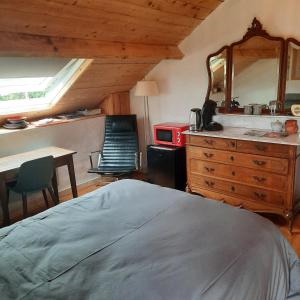 a bedroom with a bed and a table and a kitchen at Chambre d'hôte Le Châtaignier in Planchez