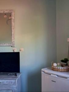 a living room with a tv and a dresser with a tvictericter at Helen's studio in Leptokarya