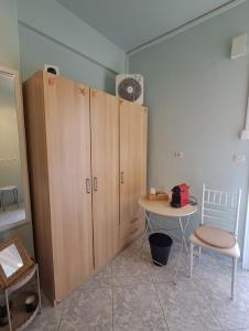 a room with wooden cabinets and a table and a fan at Helen's studio in Leptokarya