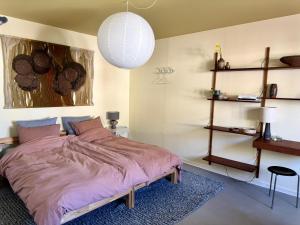 a bedroom with a bed with a purple comforter at Groland Bornholm B&B in Pedersker
