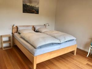 a bed with two pillows on it in a room at Haus zum See in Uhldingen-Mühlhofen