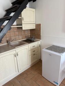 a kitchen with white cabinets and a sink and a refrigerator at La Meridiana in Faleria +16 photos