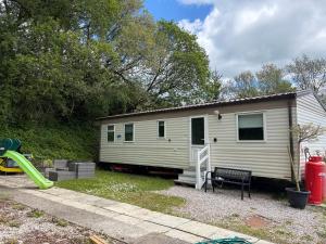 a white tiny house with a playground and a slide at Lisa retreat in Preston