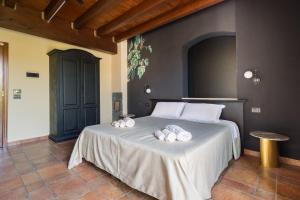 a bedroom with a bed with towels on it at Capomulini Boutique Hotel in Capo Mulini