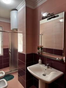 a bathroom with a sink and a shower and a mirror at Apartment in Durres Elio in Golem