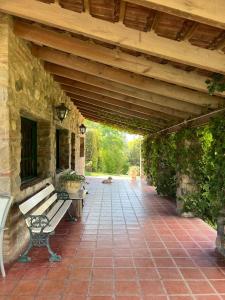 a patio with a bench under a wooden roof at Quinta lo de Dito in Villa Allende